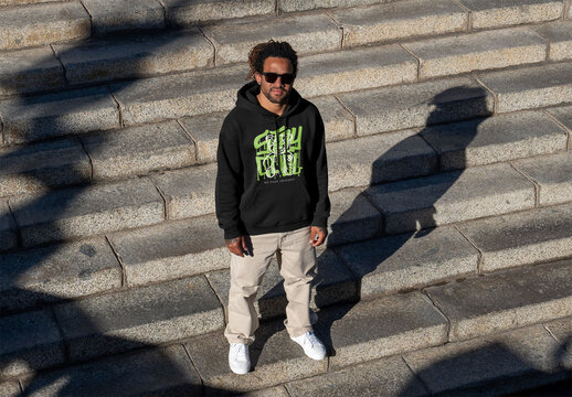 Mockup of man on steps wearing customizable hoodie