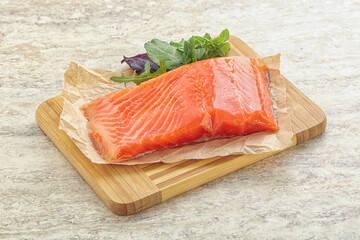 Raw salmon fillet over board