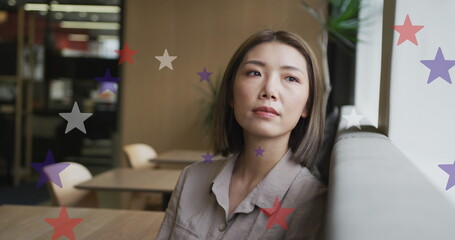 Image of stars of flag of usa over asian businesswoman in office