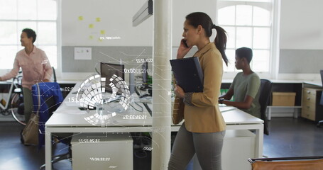 Image of data processing and globe over biracial businesswoman talking on smartphone in office