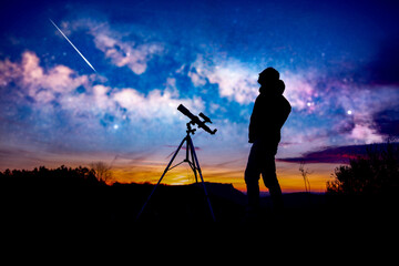 Amateur astronomer looking at the evening skies, observing planets, stars, Moon and other celestial objects with a telescope.