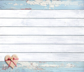 Vintage travel backdrop with heart made of linen tissue on wood boards of white and light blue color.  Horizontal retro background with old wooden planks and tiny toy heart. Copy space for text