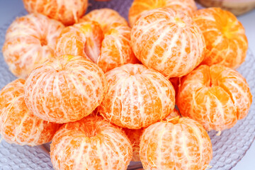 a bunch of peeled oranges on a glass plate
