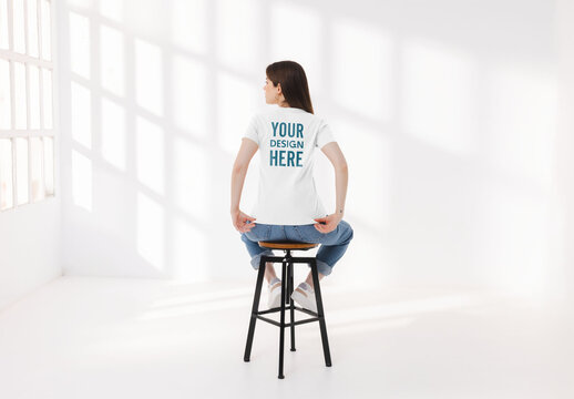 Mockup of woman wearing customizable t-shirt on stool