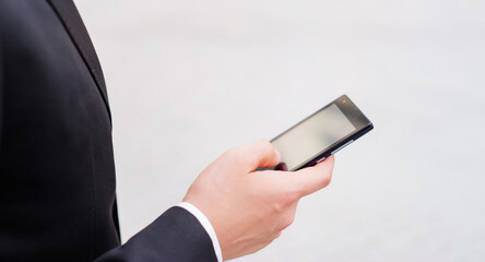 Close up of the hand of the businessman with a smartphone.