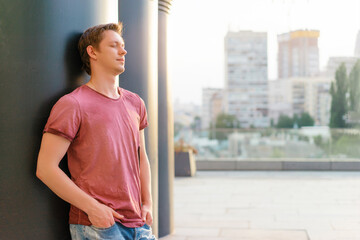 Handsome and relaxed. Young man in casual wear standing outdoors with eyes closed.