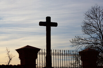 Silhouette of Christian Cross and Iron Gate at Dusk