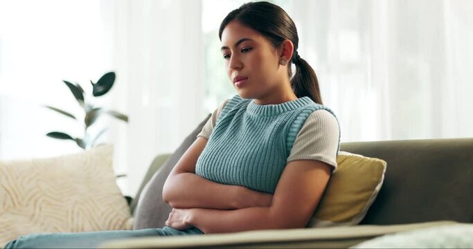 Sick, stomach pain and woman on sofa in living room with menstruation, gas or constipation at home. Gut health, ibs and female person with tummy ache for pms, nausea or endometriosis at apartment.