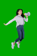 Happy female teen shouting on a megaphone while jumping