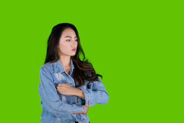 Thoughtful Asian woman looks pensively against green background