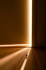 An apartment room door is ajar with interior light shining on a small toy soldier.