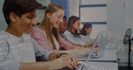 Image of math formulas moving over happy diverse pupils working on laptops