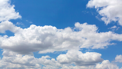 Fluffy cumulus clouds on bright clear sky, nature atmosphere background