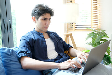Young man working with laptop computer at home, work from home, online learning - 785120579
