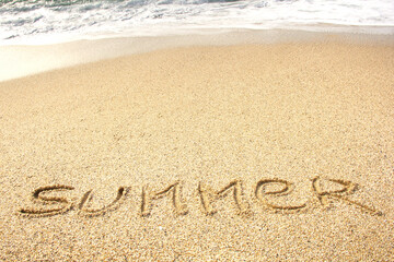 Fototapeta na wymiar the inscription summer on the sea sand on the beach. selective focus . High quality photo