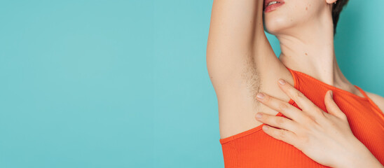 A hairy female armpit. A woman showing natural vegetation on her body. Panoramic banner. a place for the text.