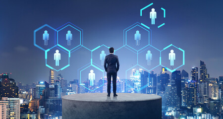 Businessman on a concrete plate, cityscape and human resources icons