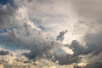 Closeup shot of white dramatic fluffy clouds and sunset in the blue sky
