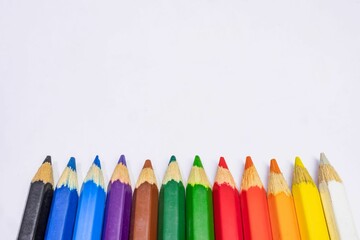 Row of colored pencils on a white background