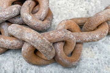 Closeup shot of a rusty iron chain on the gray background