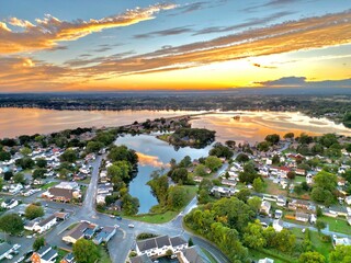 Aerial shot of a small town on the edge of a lake with the golden sunset in the background