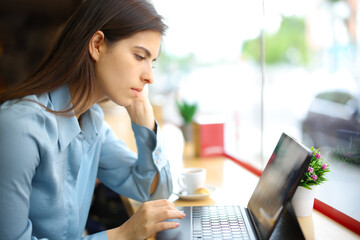 Elegant woman in a coffee shop using tablet or laptop