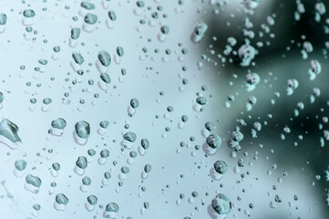 raindrops on glass window of car with cloudy sky in the background 1