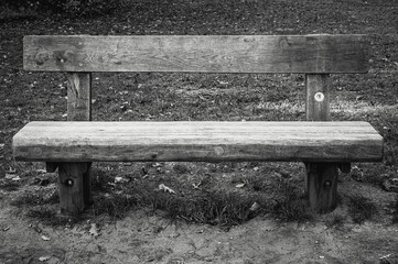 Grayscale shot of park wooden bench