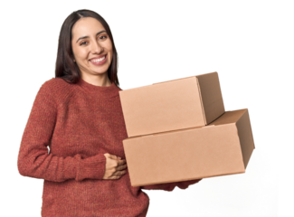 Caucasian young woman with moving boxes on studio background laughing and having fun.
