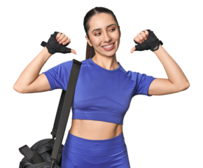 Athletic Caucasian young woman with gym bag on studio background feels proud and self confident, example to follow.