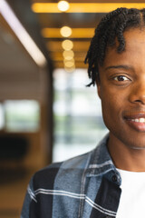 Fototapeta premium African American man standing indoors in a modern business office, looking at camera with copy space