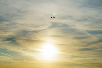 Silhouette of a paraglider flying in the sunset sky