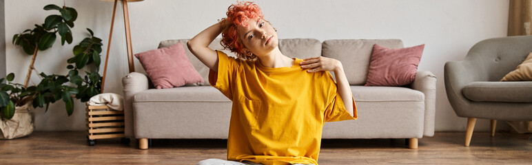 sporty queer person in t shirt with red hair stretching her muscles and looking at camera, banner