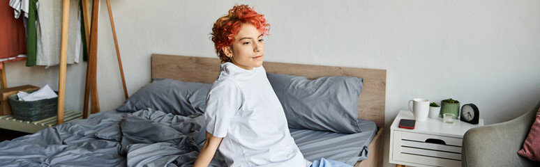 attractive extravagant person in white t shirt with red hair sitting on bed, leisure time, banner