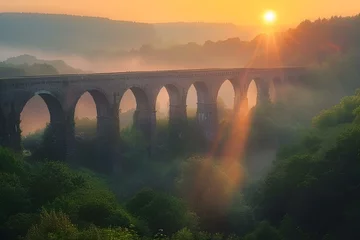 Fototapeten the sun rises over a beautiful landscape near a bridge at dawn © Wirestock