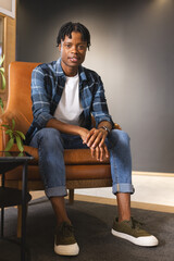 African American man sitting in chair in a modern business office, wearing casual clothes