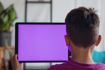 Application mockupover the shoulder shot of a boy holding an ebook with a fully purple screen