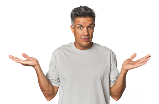 Middle-aged Latino man confused and doubtful shrugging shoulders to hold a copy space.