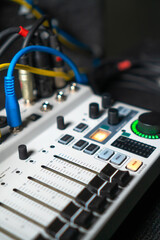Close-up image of hand adjusting mixer knob for volume control during live studio performance....