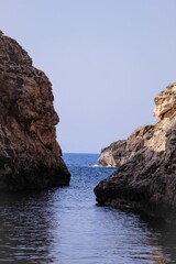 Fototapeta na wymiar Wide shot of two rocks on Wied Babu river in the Blue Grotto, Zurrieq, Malta