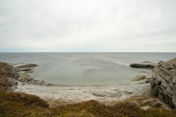 Beautiful view from the rocky coast of an ocean with rocks and grassy land in Newfoundland