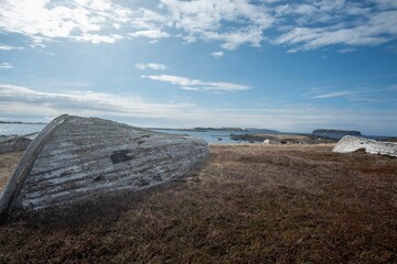 Obraz premium Coastal landscape with old wooden boats in L'Anse aux Meadows in Newfoundland, Canada