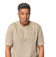 Obraz premium Middle-aged Latino man shrugs shoulders and open eyes confused.