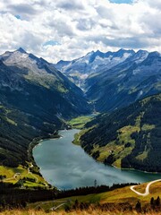 Vertical shot of a majestic alpine landscape with a river flowing between the mountains © Wirestock