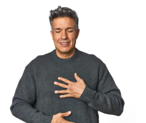 Middle-aged Latino man laughs happily and has fun keeping hands on stomach.