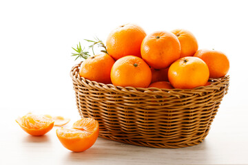 Fresh tangerine orange fruits in wooden basket.