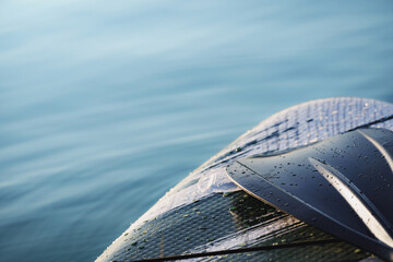 Close up and detail of a Stand Up Paddle surf board or SUP on the lake with copy space.