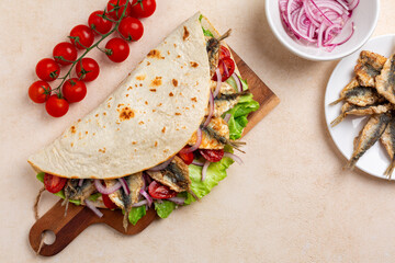 Top view of Traditional italian wrap or open sandwich. Piadina romagnola con sarde fritte. Fatbread...