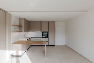 Interior of a modern kitchen with a wooden table or worktop. Everything is new and there are no objects around - 785163904