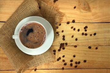 Closeup shot of a coffee surrounded by coffee beans